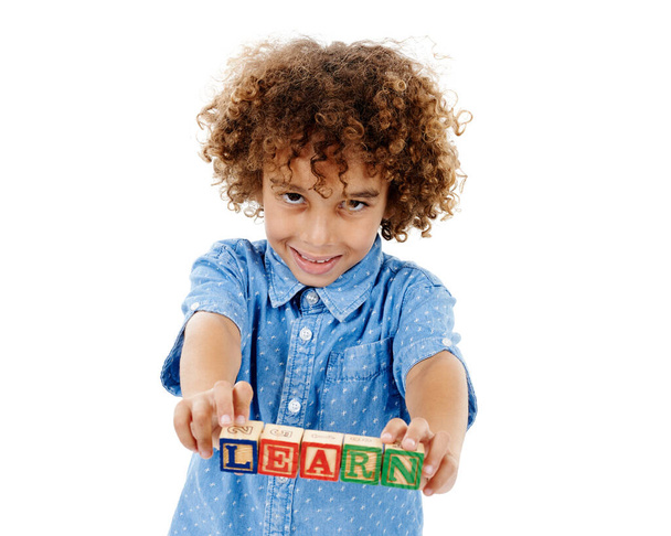 Never stop learning. Studio shot of a cute little boy holding building blocks that spell the world learn against a white background - Φωτογραφία, εικόνα