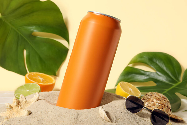Can of soda with seashells, sunglasses and citrus fruits on sand, closeup - Фото, зображення