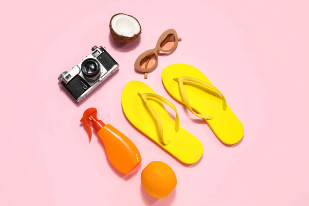 Beach accessories with photo camera and fruits on pink background - Photo, Image