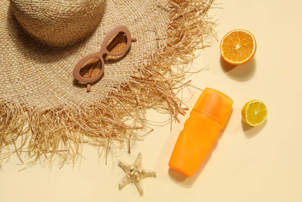 Sombrero de verano con gafas de sol, estrella de mar, crema protector solar y frutas sobre fondo beige - Foto, imagen