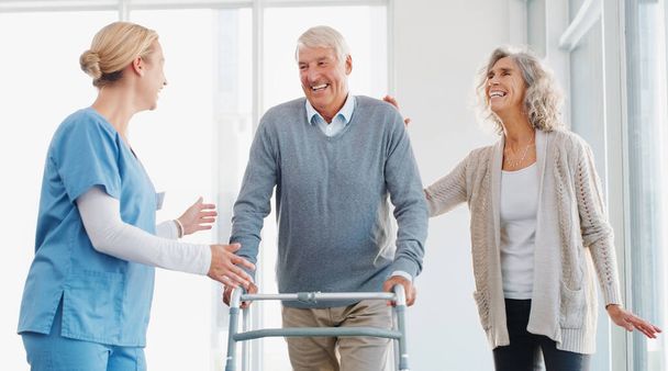 A dar-lhe o cuidado que merece. um homem idoso usando um andador com a ajuda de sua esposa e jovem enfermeira - Foto, Imagem
