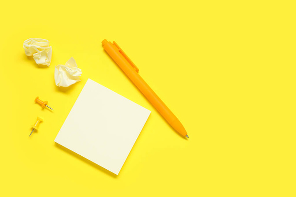 Pen met kleverige notities en spelden op gele achtergrond - Foto, afbeelding