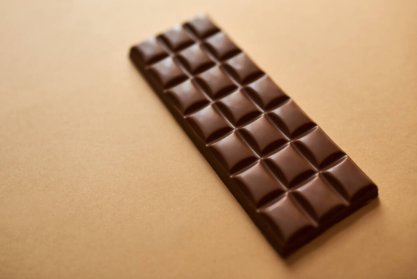 Hayat olur, çikolata yardımcı olur. Kahverengi arka planda bir parça çikolatanın stüdyo çekimi - Fotoğraf, Görsel