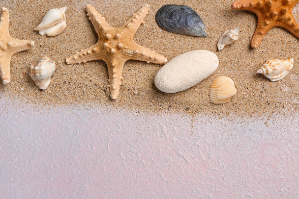 Muscheln und Seesterne mit Sand auf fliederfarbenem Hintergrund - Foto, Bild