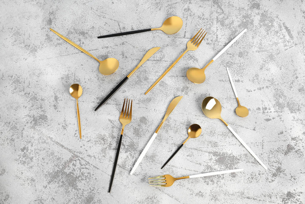 Golden cutlery on grey background - Foto, afbeelding