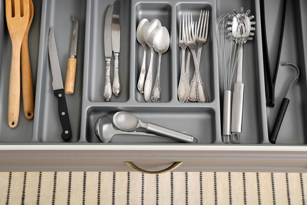 Open kitchen drawer with different silver cutlery - Foto, Imagen
