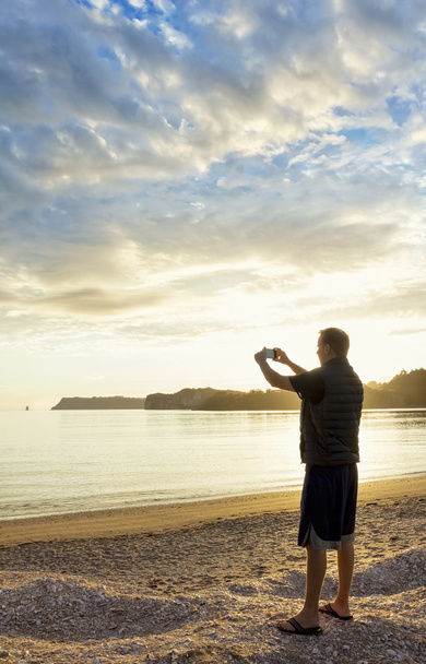 Man taking photos of a beautiful sunset - Фото, зображення
