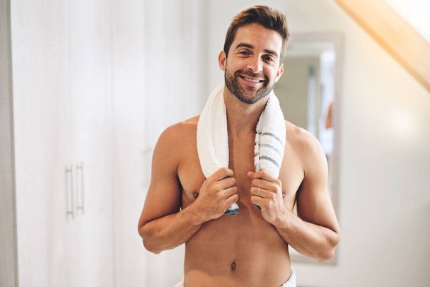 Time for a shower. Cropped portrait of a handsome young man holding a towel around his neck in his bathroom at home - Fotografie, Obrázek