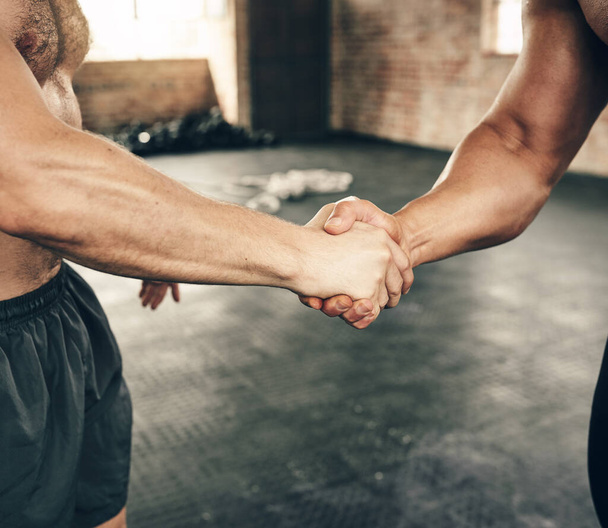 Podwój siłę. dwóch nierozpoznawalnych mężczyzn witających się uściskiem dłoni podczas ćwiczeń na siłowni - Zdjęcie, obraz