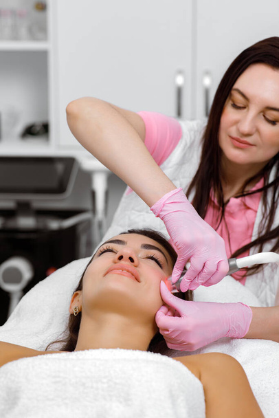 Facial treatment,cosmetic procedure, Acne therapy,lifting procedure,cosmetologist performs facial treatments for a customer at an aesthetic medical clinic - Foto, Imagen
