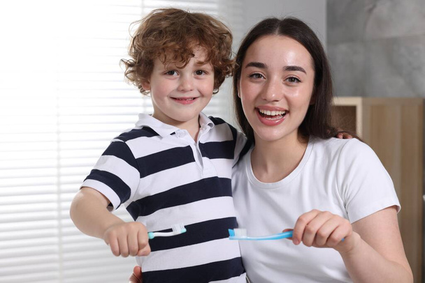 Mother and her son brushing teeth together in bathroom - Valokuva, kuva
