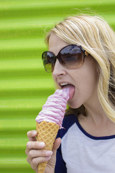 Cute woman licking an ice cream cone - Photo, Image