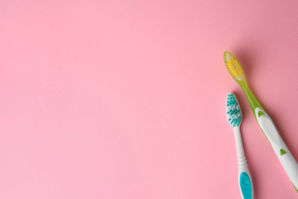 Toothbrushes on pink background, flat lay. Space for text - Foto, Bild