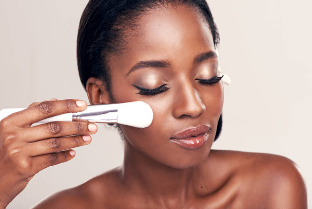 Beauty, makeup and glow, black woman with brush on face in studio with cosmetic application tool. Skincare, healthy blush and cosmetics, facial skin care model with luxury contour on white background. - Foto, Bild