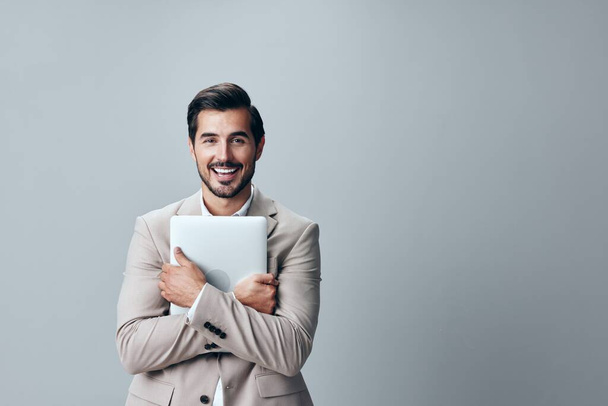 男スタイリッシュなラップトップデジタル人コンピュータビジネスジョブベージュシャツ起業家コピスペース笑顔インターネットビードスーツ大人のフリーランサー陽気なネットワークオフィス - 写真・画像