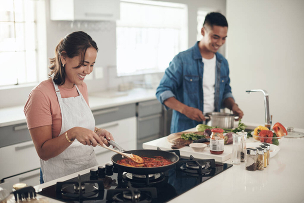 Whipping up something tasty together. a young couple cooking together at home - Photo, Image