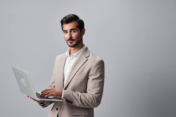 άνθρωπος επιχειρηματικό πορτρέτο υπολογιστή κοστούμι δίκτυο εταιρικό internet σε απευθείας σύνδεση επιχειρηματίας δουλειά χαμογελώντας γραφείο στούντιο όμορφος copyspace laptop τεχνολογίας νεαρός ασύρματος ελεύθερος επαγγελματίας - Φωτογραφία, εικόνα