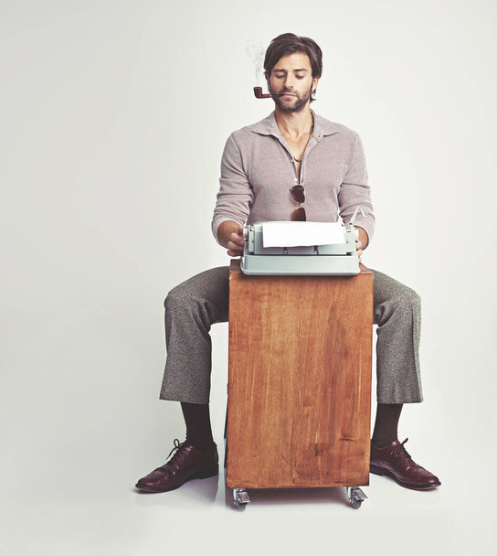 Palataan perusasioiden kirjoittamiseen. Nuori mies 70-luvun tyyliin vaatteet kirjoituskoneen avulla - Valokuva, kuva