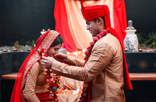 Esküvő, házasság és virágok egy párral a szerelem ünneplésére egy szertartáson. Boldog, romantikus vagy iszlám egy hindi menyasszonnyal és vőlegénnyel, akik a kultúrájuk hagyománya szerint szabadtéren házasodnak.. - Fotó, kép