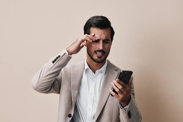 mężczyzna młody połączenie telefon komórkowy uśmiech trzymać szczęśliwy przystojny telefon odizolowany blogger smartfon studio garnitur telefon handel biznesmen biznes portret technologia połączenie - Zdjęcie, obraz