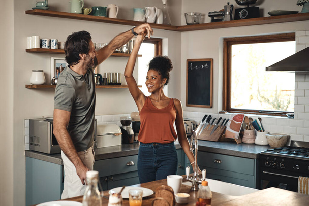 Interracial couple, dance and love in kitchen for romance, fun bonding or holiday together at home. Happy man and woman dancing in joyful happiness for romantic relationship or enjoying weekend house. - 写真・画像