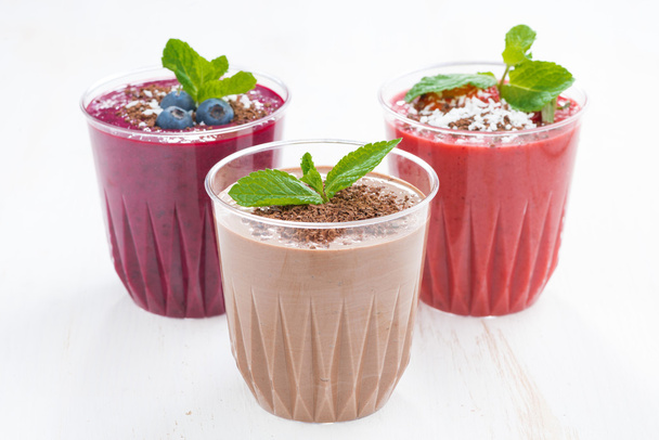 Chocolate, blueberry and strawberry milkshakes in glasses - Zdjęcie, obraz