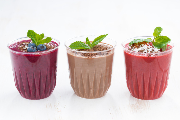 Chocolate, blueberry and strawberry milkshakes in glasses - Foto, afbeelding