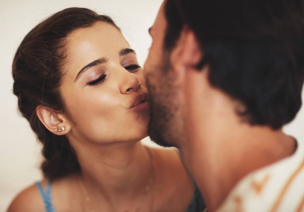 You deserve a kiss. an affectionate young couple bonding at home - Foto, imagen