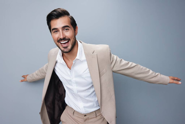 victory man isolated businessman studio cheerful male happy up smiling success shirt arm stylish hand winner beige work suit model business - Photo, Image