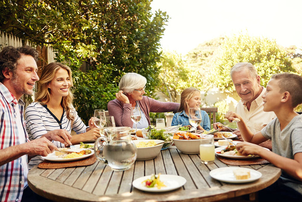Rodzinne spotkania są najlepsze. rodzina jedząca razem lunch na świeżym powietrzu - Zdjęcie, obraz