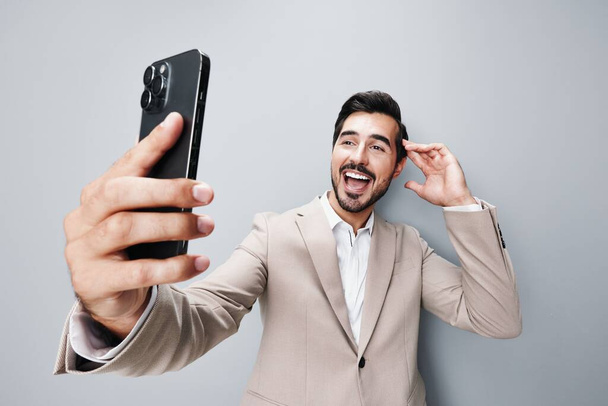úsměv muž komunikace mobilní izolované mužské oblek aplikace obchodní telefon připojení on-line studio hovor smartphone šťastný kyberprostor jistý portrét firemní držení - Fotografie, Obrázek