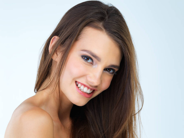 Makeup, beauty and portrait of woman with smile on blue background for wellness, skincare and spa treatment. Salon aesthetic, dermatology and face of happy girl with cosmetics, confidence and facial. - 写真・画像