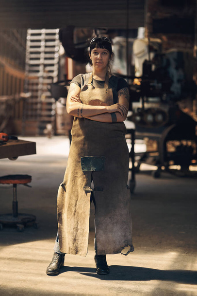 Find your power and forge ahead with it. Portrait of a confident young woman working at a foundry - Foto, afbeelding