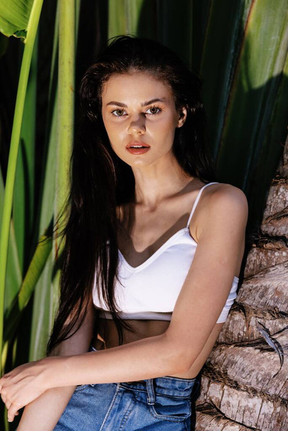 Kauneus muotokuva nuori nainen edessä palmuja, kasvot ja vartalo ihonhoito käsite, tropiikissa, mainonta kauneudenhoitotuotteita. Laadukas kuva - Valokuva, kuva