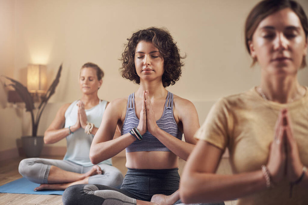 Meditace je způsob, jak udržet rovnováhu. mladá skupina žen sedících spolu a meditujících po vnitřní józe - Fotografie, Obrázek