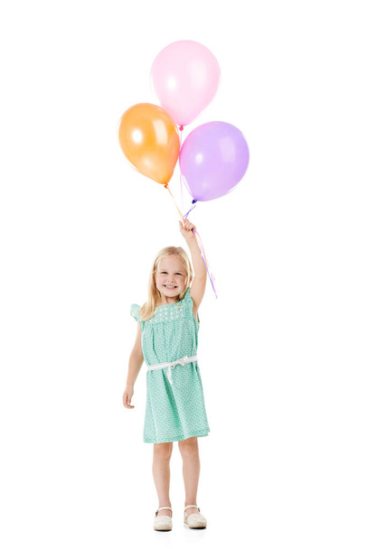 Fille d'anniversaire. Plan studio d'une jolie petite fille tenant un tas de ballons sur un fond blanc - Photo, image