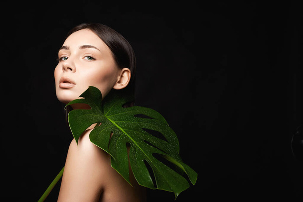 beautiful girl with palm leaves. Beautiful young woman with Make-up. Beauty Portrait. Natural cosmetics - Φωτογραφία, εικόνα