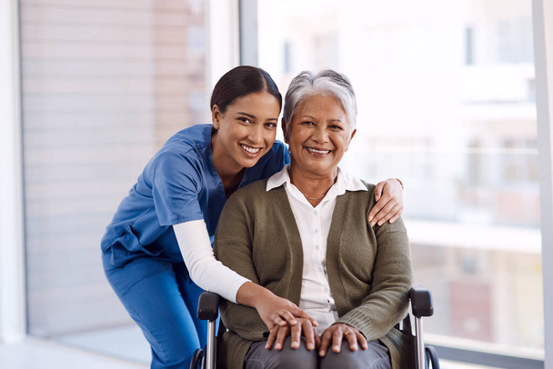 Πορτρέτο, χαμόγελο και νοσοκόμα με μια ηλικιωμένη γυναίκα σε αναπηρική καρέκλα, φροντίδα και αποκατάσταση. Πρόσωπο, ευτυχισμένη γυναίκα και ηλικιωμένη κυρία με ιατρικό επαγγελματία, ανάρρωση και άτομο με αναπηρία. - Φωτογραφία, εικόνα
