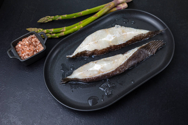 raw fish on a black plate - Valokuva, kuva