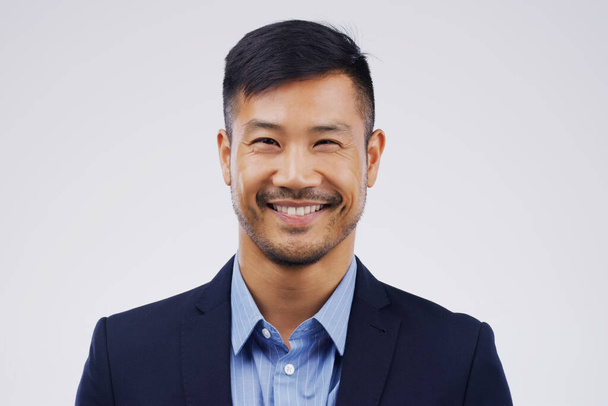 Portrait, business and Asian man with a smile, lawyer and confident guy against a grey studio background. Face, male person and employee with happiness, agent and career development with professional. - Zdjęcie, obraz