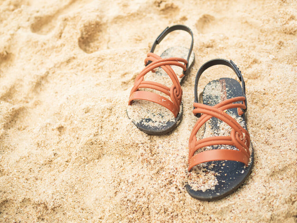 Сандалии на пляжном фоне, аксессуары для летнего отдыха на берегу моря, мода на тапочки и отдых на природе. - Фото, изображение