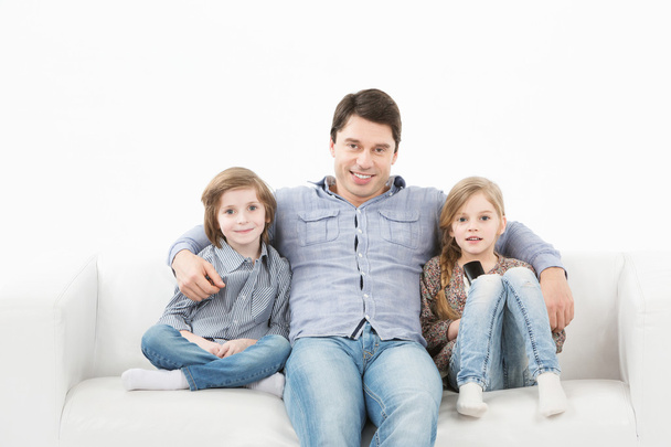 Family sitting on sofa smiling at camera on white background - Photo, Image