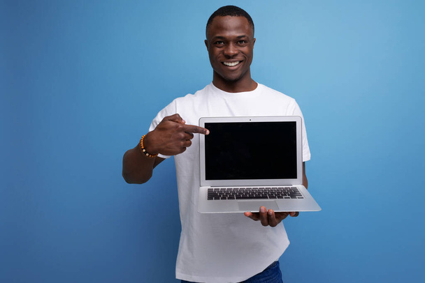 alkalmi 30-as afrikai férfi rövid frizurával fehér póló képernyők promóciós ajánlat. - Fotó, kép