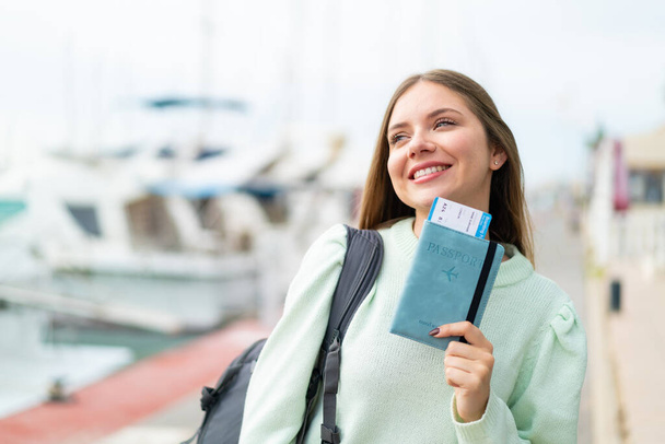Young pretty blonde woman holding a passport with happy expression - Photo, Image