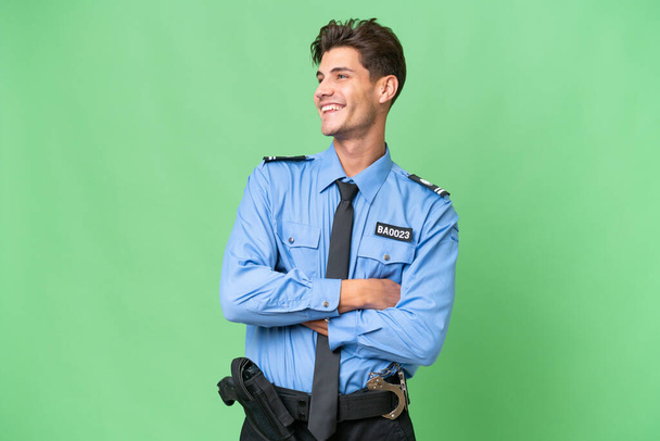 Mladý policista přes izolované pozadí šťastný a usmívající se - Fotografie, Obrázek