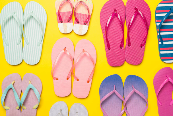 Many bright flip flops on color background, top view - Photo, Image