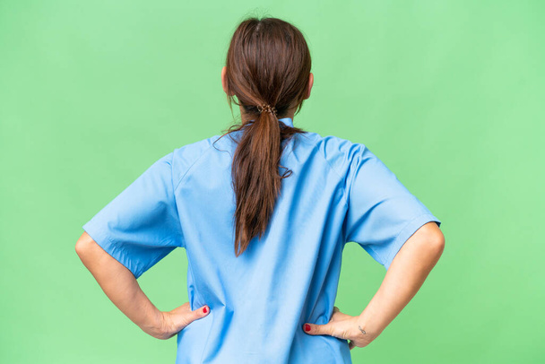 Middle-aged nurse woman over isolated background in back position - Foto, Imagen