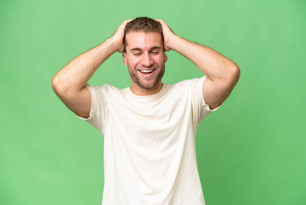 Young handsome caucasian man isolated on green chroma background laughing - Zdjęcie, obraz