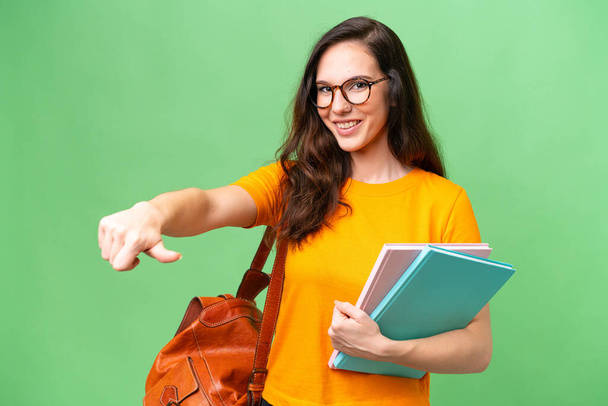 Young student caucasian woman over isolated background giving a thumbs up gesture - Foto, Imagem