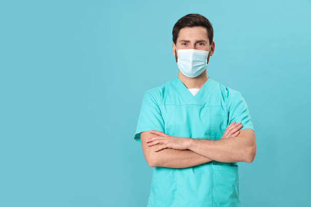 Nurse with medical mask on light blue background, space for text - Foto, afbeelding